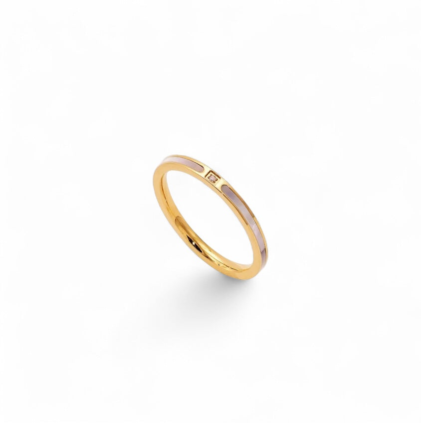 Gold ring with a small diamond on a mother of pearl background